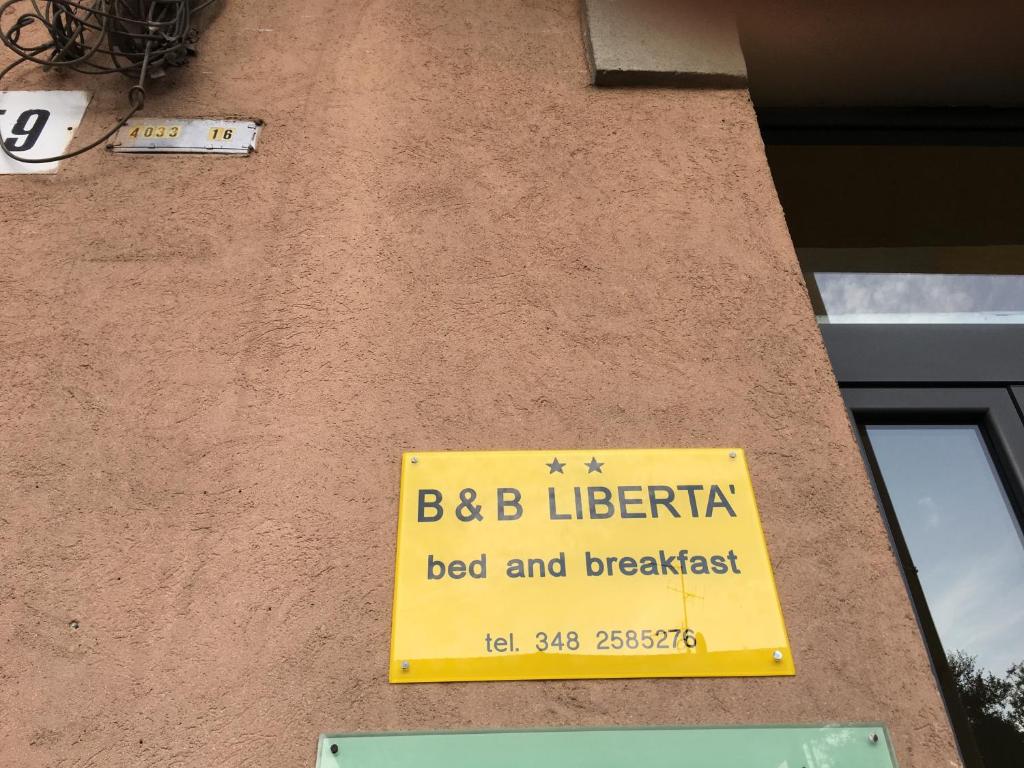 比耶拉B&B Libertà的建筑物一侧的黄色标志
