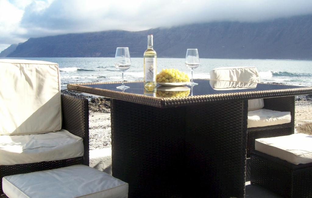 法马拉Absolute Beachfront House II的一张桌子、两把椅子和一瓶酒杯