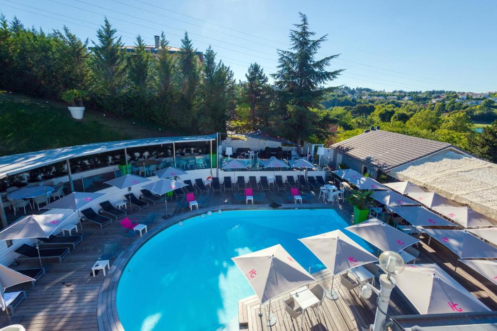 圣艾蒂安高尔夫酒店的享有带遮阳伞和桌子的游泳池的顶部景致