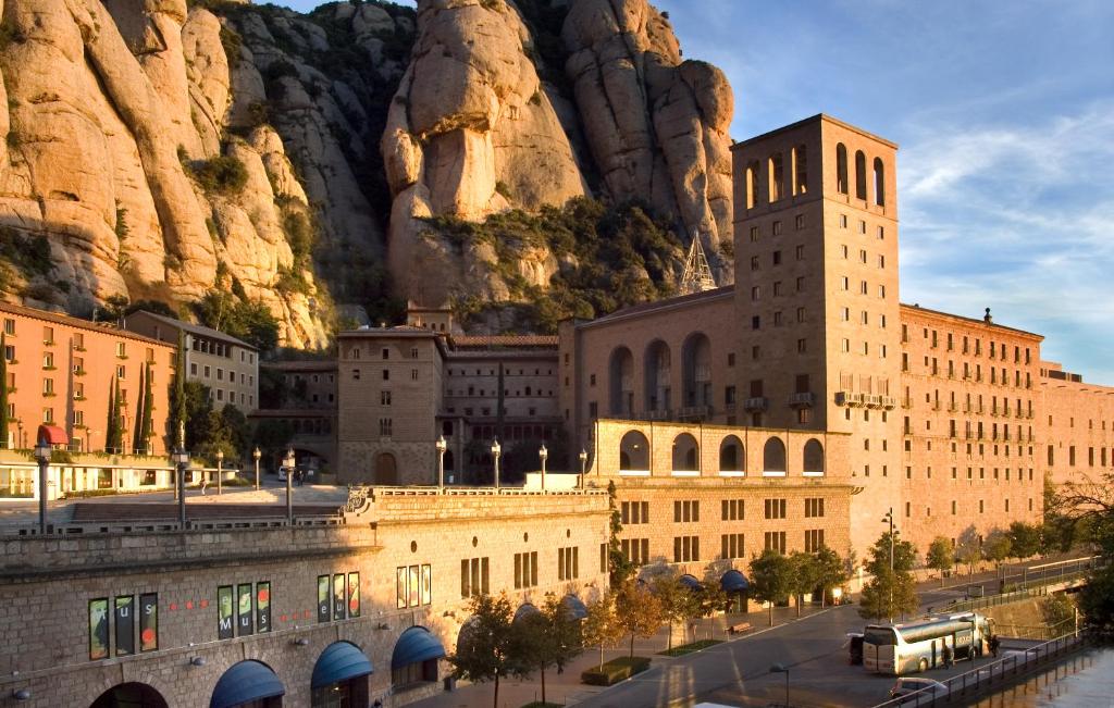 蒙塞拉特阿巴特西斯内罗斯蒙特塞拉特酒店 的一座大建筑,背景是一座山