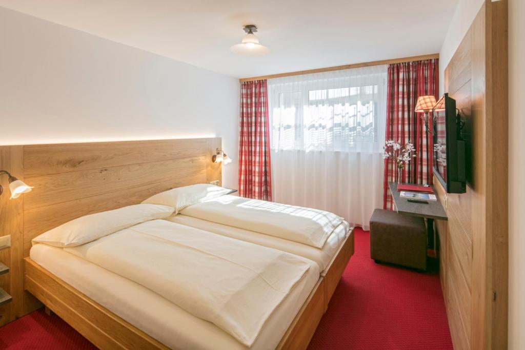 采尔马特埃内克斯安迪卡酒店的一间卧室配有一张床和一台电视