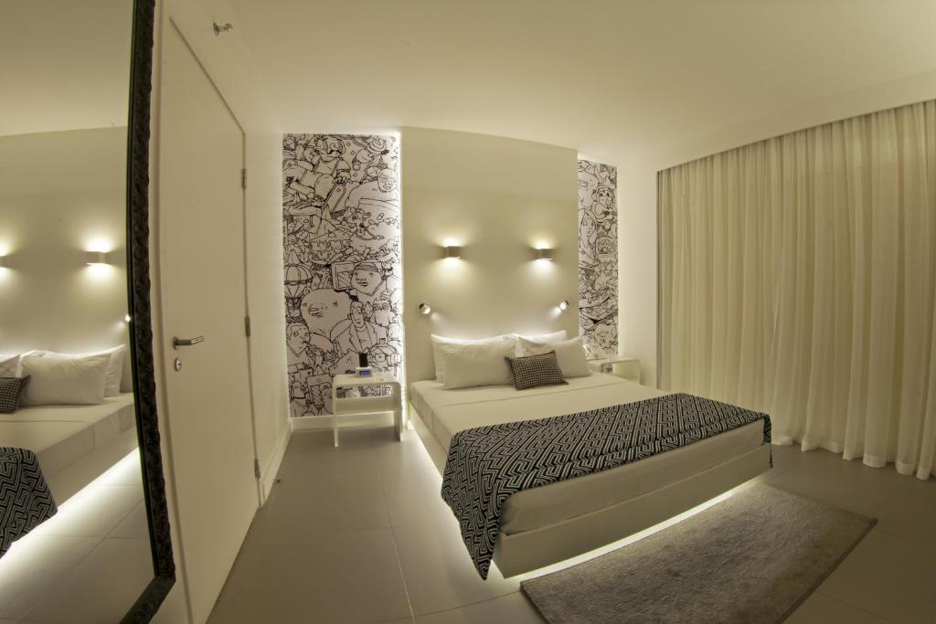 博阿维斯塔ibis Styles Boa Vista的白色卧室配有床和镜子