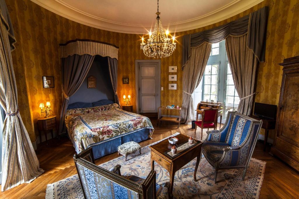 拉弗罗瑟利尔弗瑟利尔城堡酒店的一间卧室配有一张床和一个吊灯