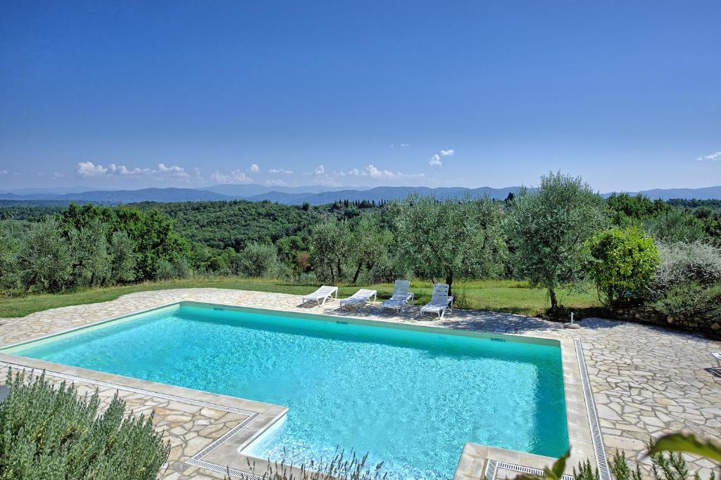 梅尔卡特勒瓦尔迪佩萨Pozzo Dei Desideri by PosarelliVillas的庭院内的游泳池,带椅子和树木