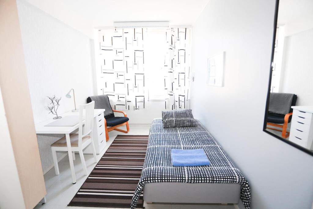 图尔库Bed&Breakfast Tuure的客房设有一张床、一张书桌和一面镜子