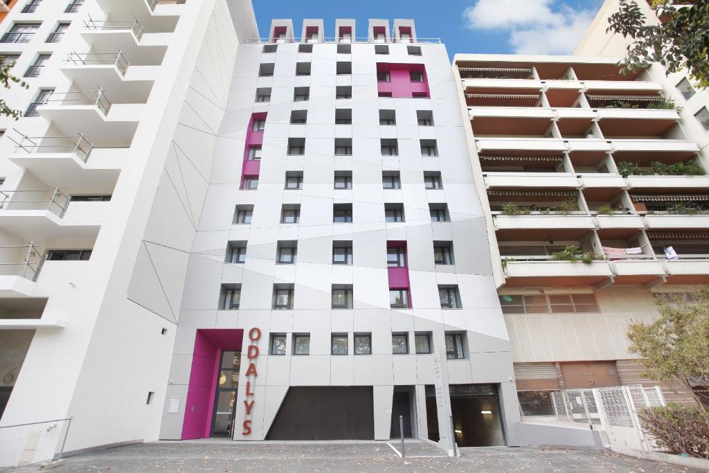 马赛马赛市奥德利圆顶公寓式酒店的白色的建筑,设有粉红色的窗户
