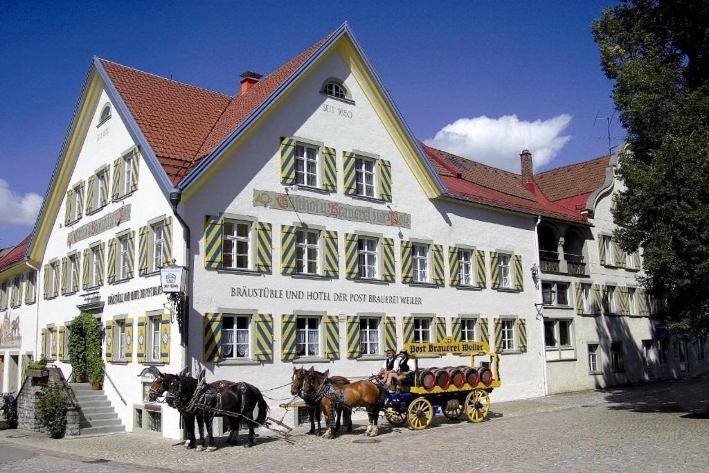 魏勒-锡默贝格帕斯特酒店的一群马在建筑物前拉马车