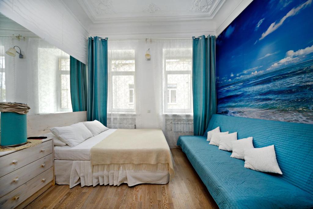 莫斯科Bulgakov Apartments的卧室配有一张床,墙上挂有绘画作品