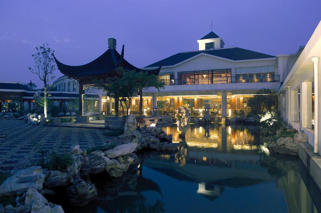 南京Jinling Resort Nanjing的前面有池塘的建筑