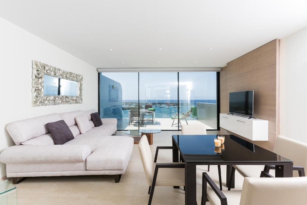 阿吉内金海滩Arguineguín Bay Apartments的客厅配有白色的沙发和桌子