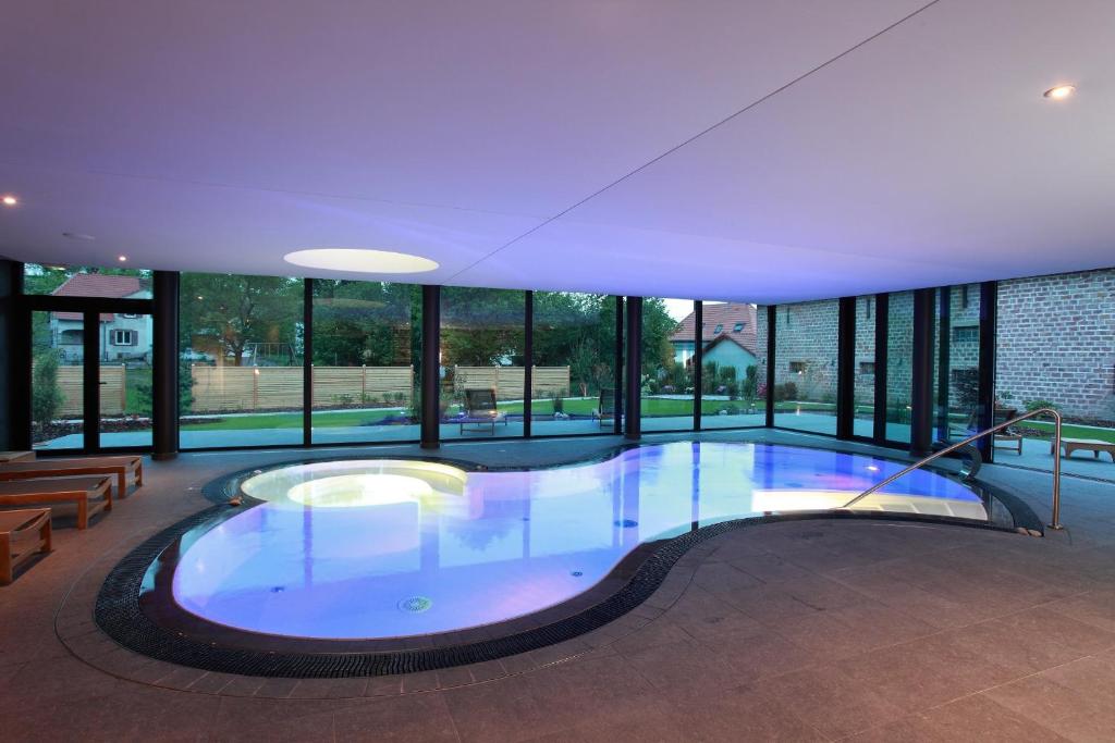 朗巴克奥伯格切瓦尔布兰科温泉酒店的一座大型游泳池,位于一座带窗户的建筑内