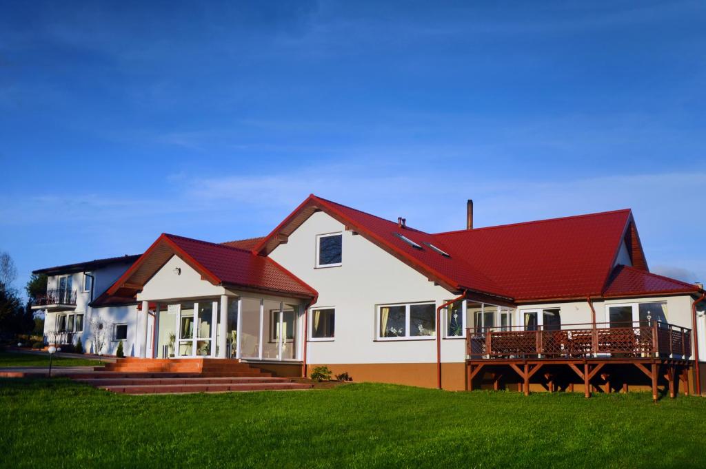 Nowogródek PomorskiZielona Dolina的一座大型白色房屋,设有红色屋顶
