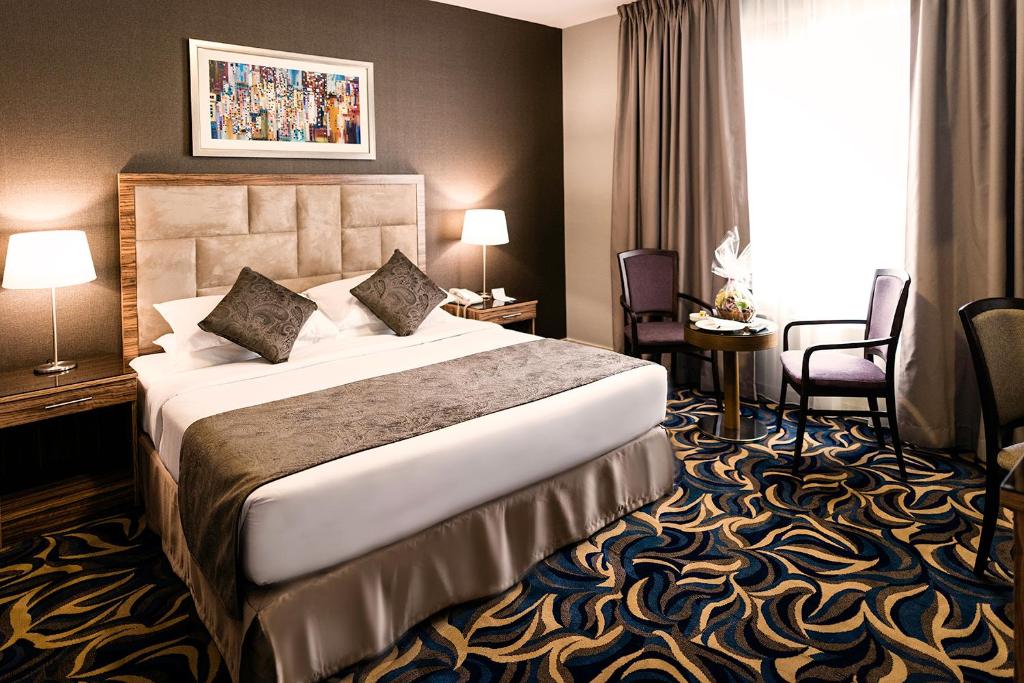 阿布扎比阿联酋广场酒店的酒店客房带床、椅子和窗户