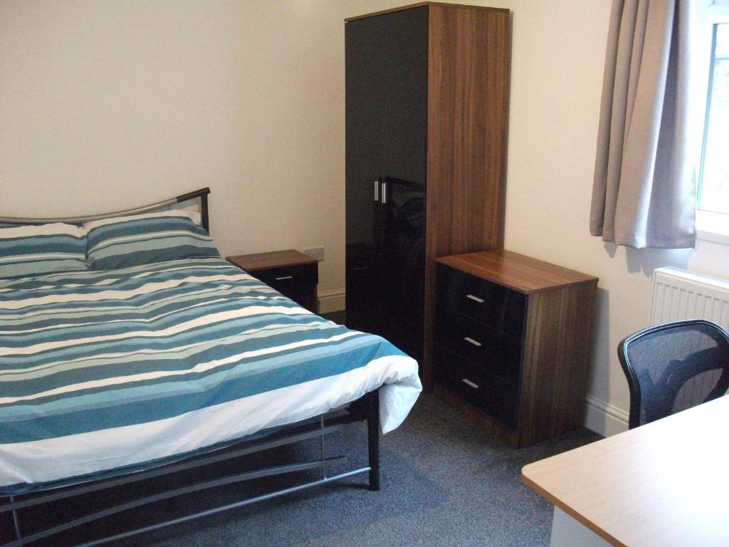 米德尔斯伯勒The Grange的一间卧室配有一张床、一张书桌和一个橱柜
