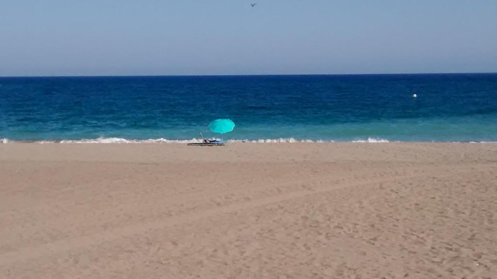 圣路易斯·德·萨比尼尔Casita Andaluza的一把蓝伞,坐在海边