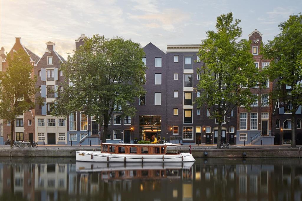 阿姆斯特丹阿姆斯特丹普利策酒店的船在水中,在建筑物前