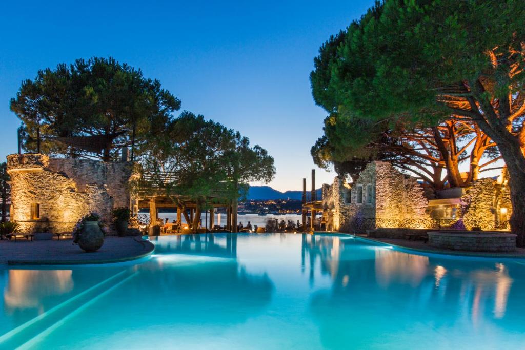 维琪奥港丽城酒店的一座种植了树木和蓝色水的大型游泳池