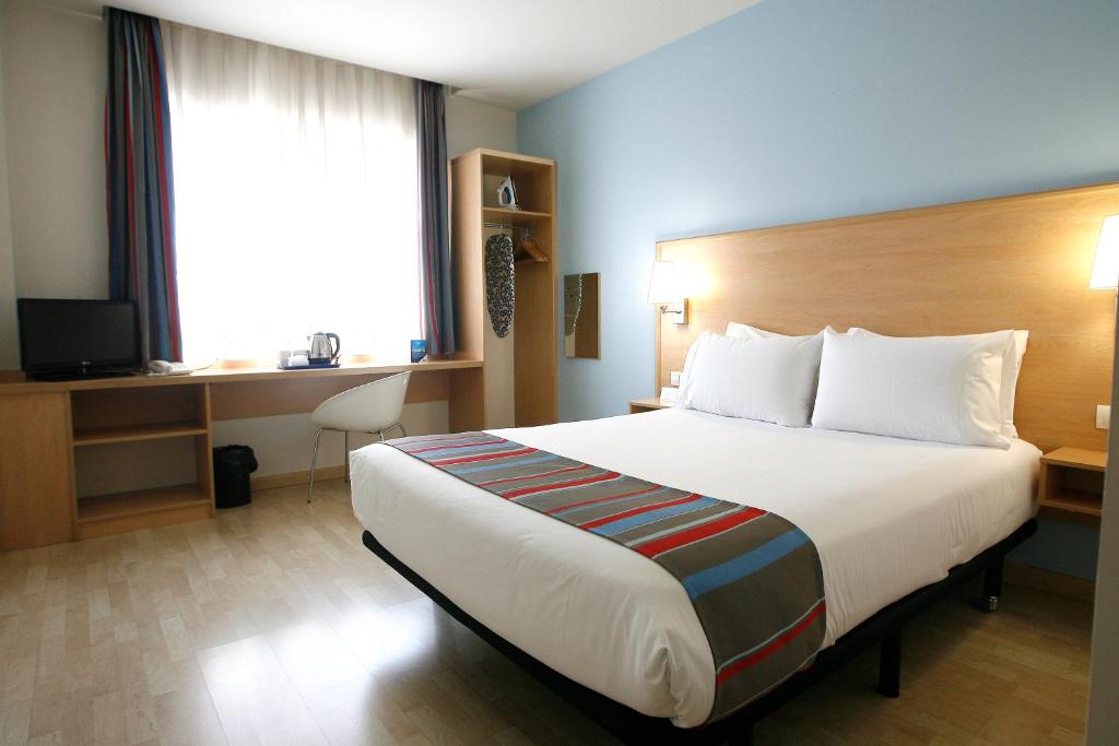 马德里托里拉古纳旅程住宿酒店的酒店客房设有一张大床和一张书桌。