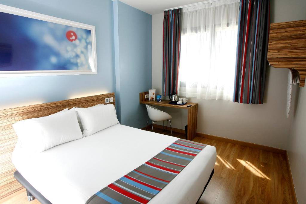 马德里Travelodge Madrid Metropolitano的卧室配有白色的床和窗户。