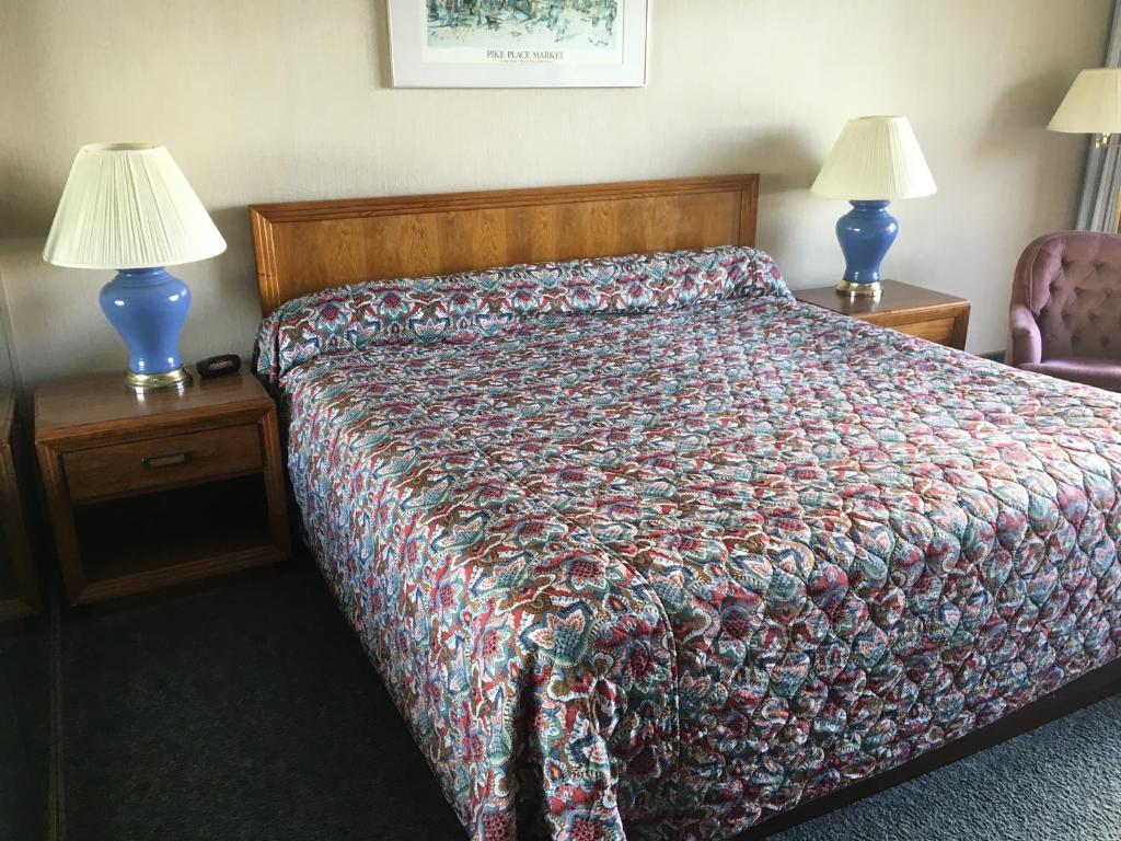 布雷默顿Flagship Inn的一张带两盏灯和床罩的房间的床铺