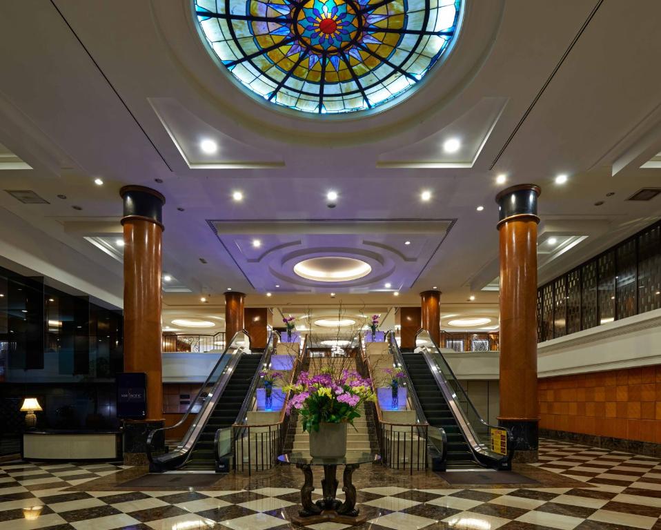 吉隆坡吉隆坡斯里太平洋酒店的大堂设有彩色玻璃窗和自动扶梯