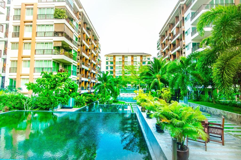 南芭堤雅格居公寓式酒店的棕榈树和建筑度假村内的游泳池