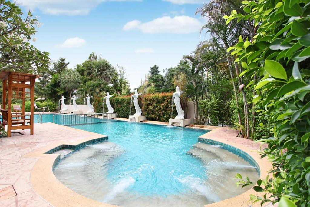 班康卡臣Nana Resort Kaeng Krachan - SHA Plus Certified的花园内带雕像的游泳池