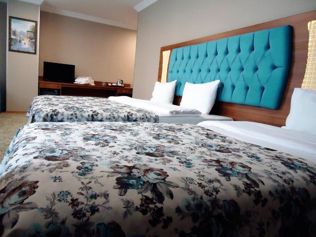 伊斯坦布尔黄金沙龙酒店的酒店客房设有两张床和蓝色床头板