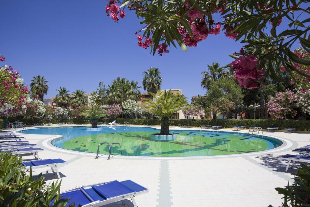 波尔托奥蒂罗卢奥西安菲特诺公寓式酒店的度假村内带椅子和树木的游泳池
