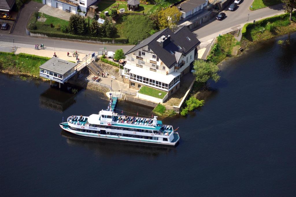 锡默拉特Garni Hotel Henn的漂浮在房子旁边的河流中的船