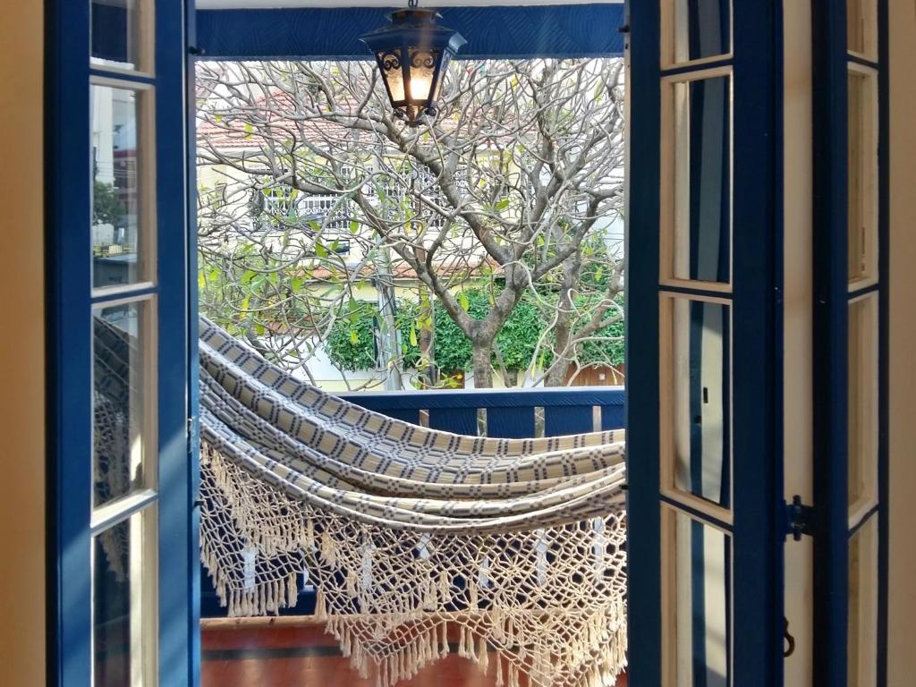 里约热内卢Farfalla Guest House的窗外的吊床上,眺望着一棵树