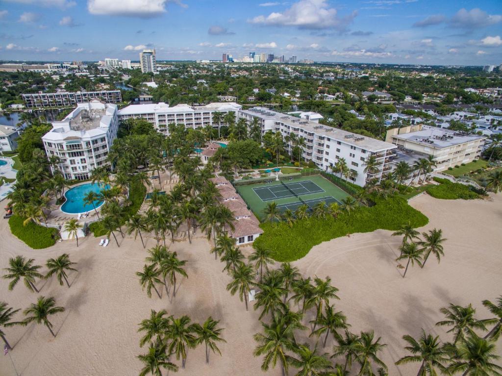 劳德代尔堡拉戈马尔海滩度假俱乐部酒店的享有度假村的空中景致,设有网球场和棕榈树