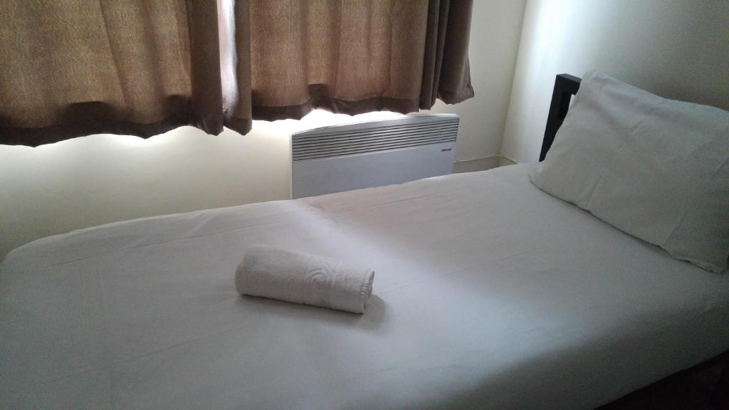 伦敦斯特拉特福德市景旅馆的一张白色的床,上面有一条可移动的毛巾