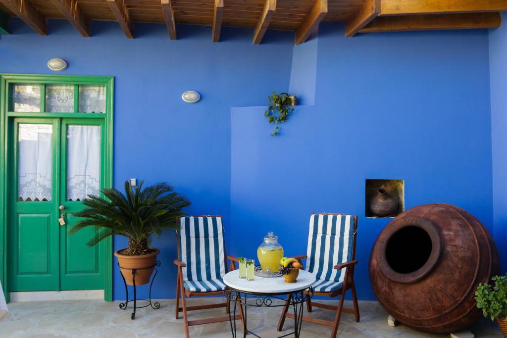 加藤德雷To Konatzi tis Marikas tzai tou Yianni的一间设有桌子和两把椅子的房间和蓝色的墙壁