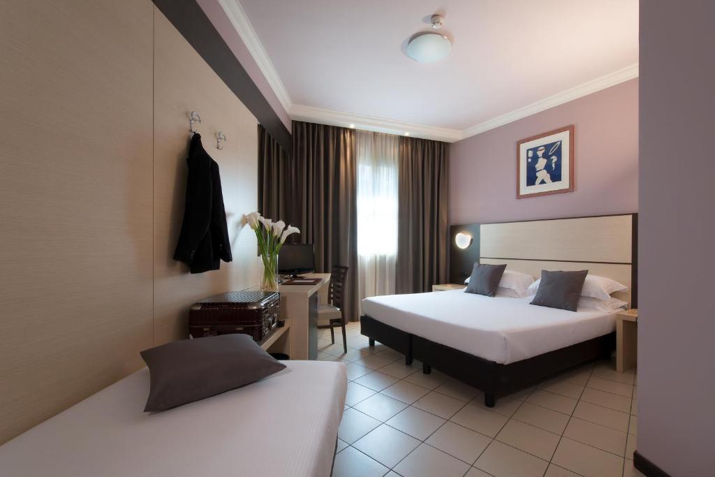 斯培西亚斯佩齐亚CDH酒店的酒店客房配有两张床和一张书桌