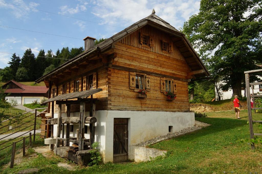 SeleTourist farm Samec的一座小木房子,有女人走过