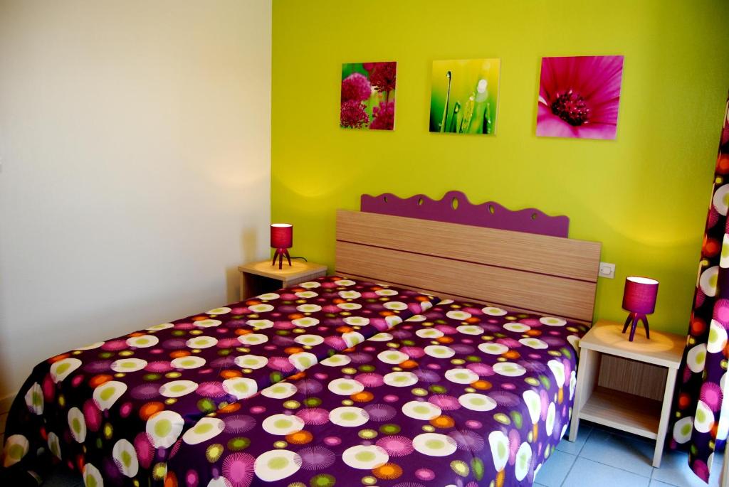 圣西普里安Lagrange Grand Bleu Vacances – Résidence Les Pierres de Jade的一间卧室配有一张带彩色床罩的床