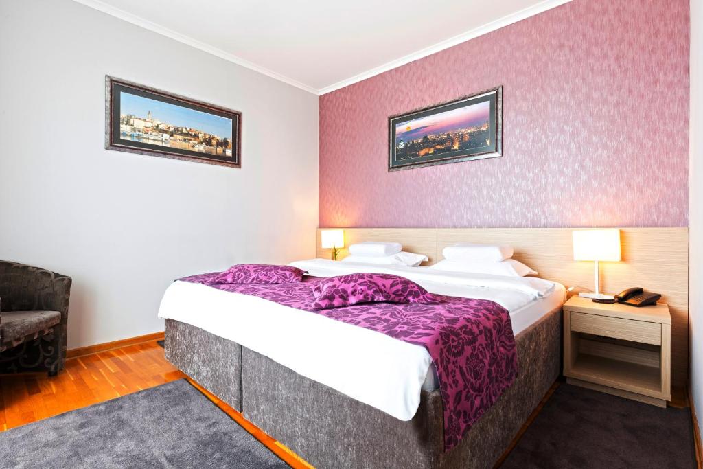 贝尔格莱德内维斯基加尔尼酒店的酒店客房,配有一张大床,提供紫色床单