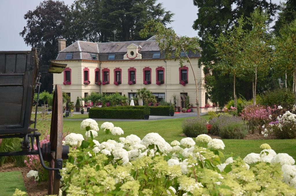Sains-du-NordLe Domaine des Fagnes的白色的大房子,红色的窗户和鲜花
