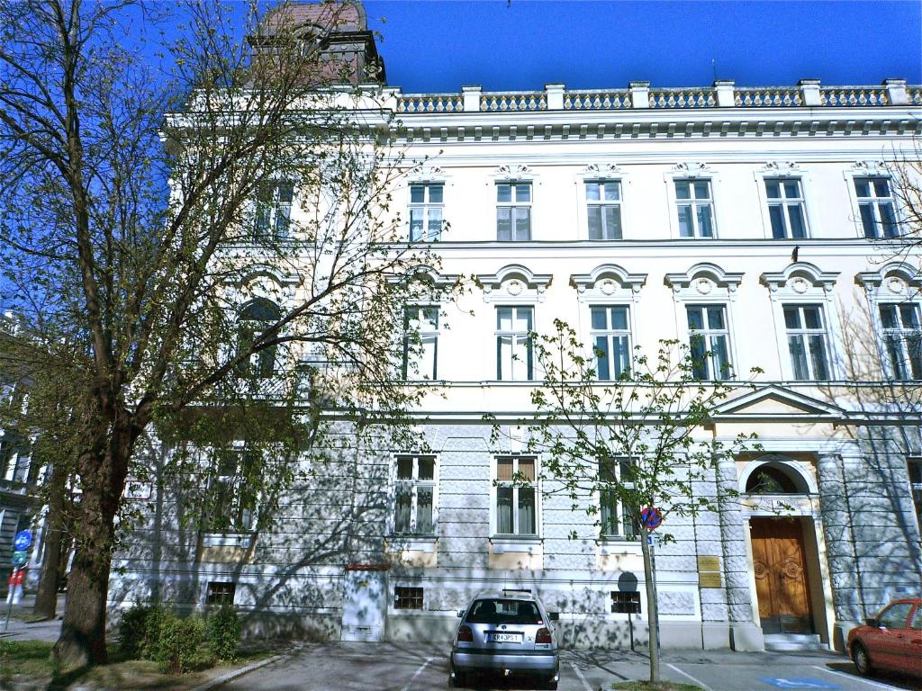 多瑙河畔克雷姆斯翁兹梅旅馆的停在白色建筑前面的汽车