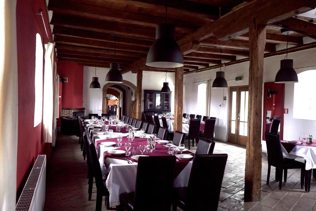 GăneştiBoutique Hotel Le Baron的一间设有桌椅和灯光的长餐厅