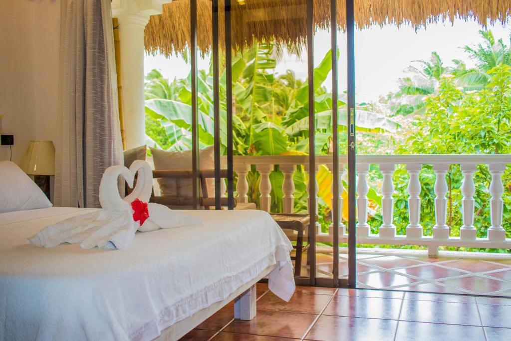 长滩岛Lanterna Hotel Boracay的一间带两张床的卧室和一个阳台