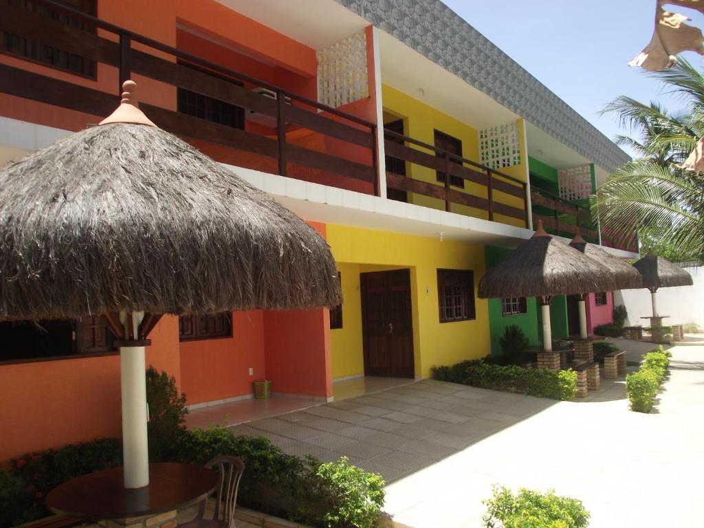 马拉戈日Privê Maragogi Residence的酒店设有带露台和遮阳伞的建筑
