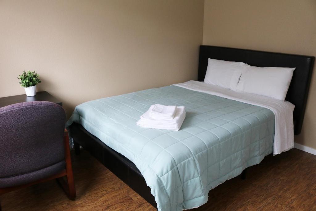 西雅图安静干净舒适旅馆的一间卧室配有一张带枕头和椅子的床