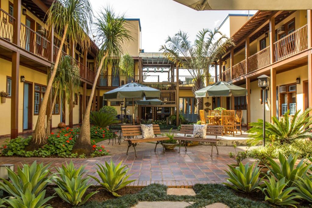 圣若昂-德雷普萨达罗图恩达酒店的庭院设有桌椅,棕榈树