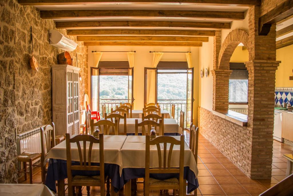 阿尔迪努瓦德拉夫拉Casa Rural Fuente El Boticario的用餐室设有桌椅和窗户。