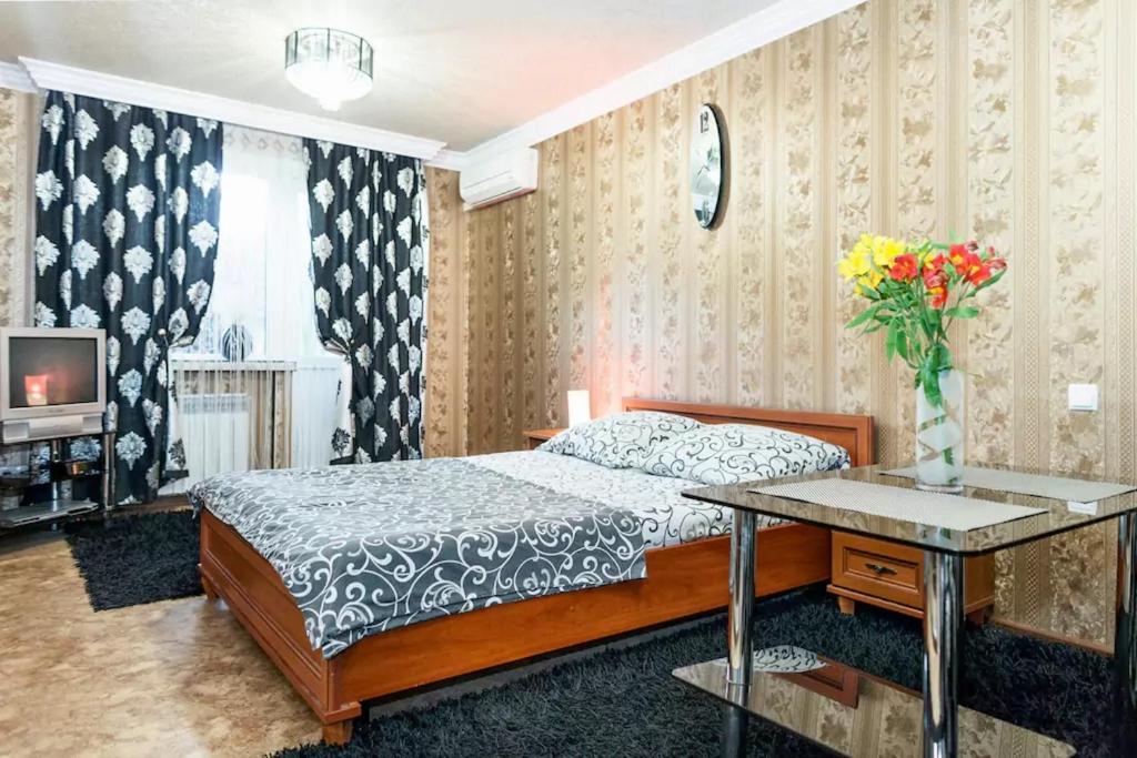 扎波罗热Apartment on Nezalezhnoy Ukrаiny near Intourist Hotel的一间卧室配有一张床和一张花瓶桌子