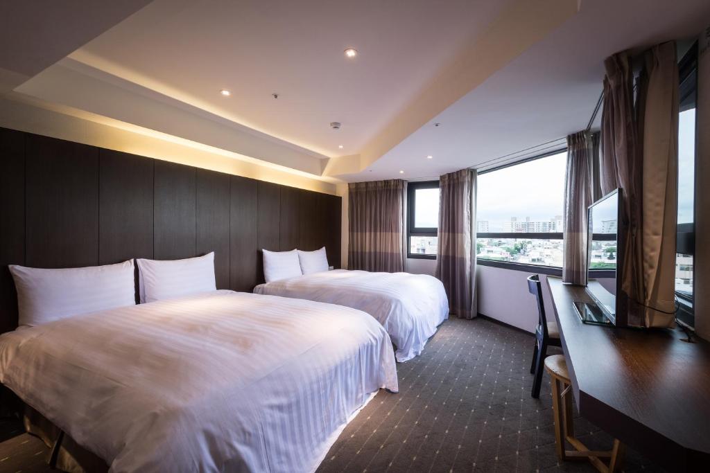 嘉义市HOTEL HI 垂杨店的酒店客房设有两张床和窗户。
