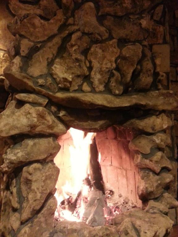 格克切达镇Uysallar Koy Evi的石头壁炉,壁炉内有火