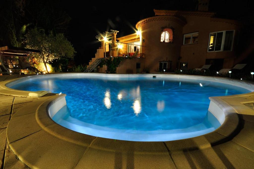 圣拉斐尔松鼠爱斯特尔住宿加早餐旅馆的夜间在房子前面的一个大型蓝色游泳池